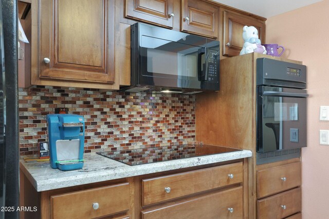 kitchen featuring decorative backsplash, brown cabinets, and black appliances