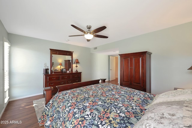 bedroom with dark wood-style floors, a ceiling fan, visible vents, and baseboards