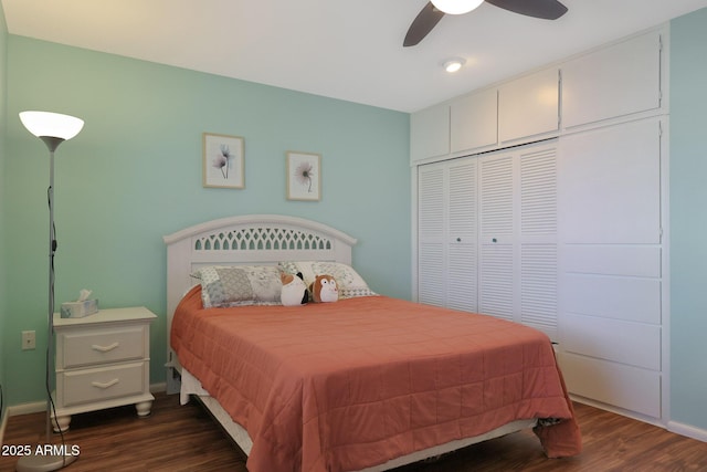 bedroom featuring dark wood-type flooring, a closet, baseboards, and a ceiling fan