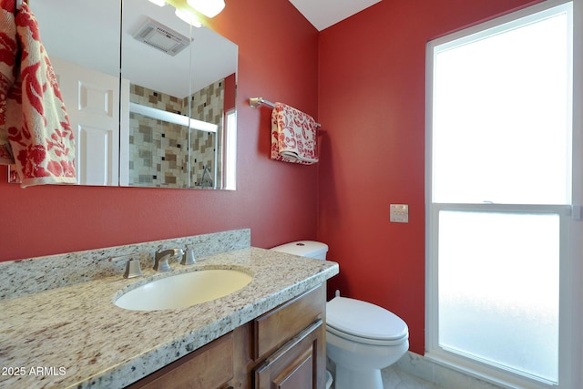 full bathroom featuring visible vents, a stall shower, vanity, and toilet