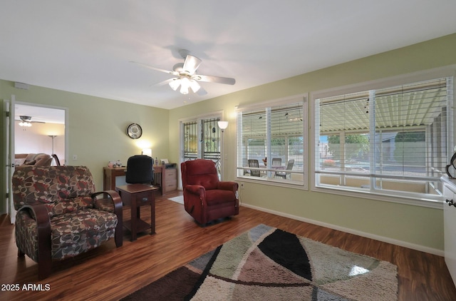 living area with a healthy amount of sunlight, baseboards, and wood finished floors