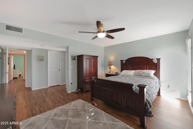 bedroom with a ceiling fan, baseboards, visible vents, and wood finished floors