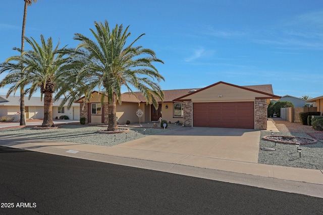 ranch-style home featuring a garage, concrete driveway, and fence