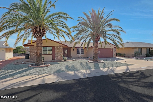 view of front of property featuring driveway, an attached garage, and cooling unit