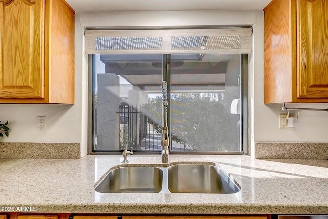 interior details featuring light stone counters and sink