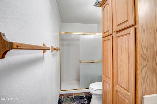 bathroom featuring an enclosed shower and toilet