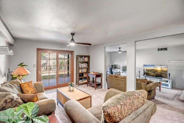 carpeted living room with ceiling fan and a textured ceiling