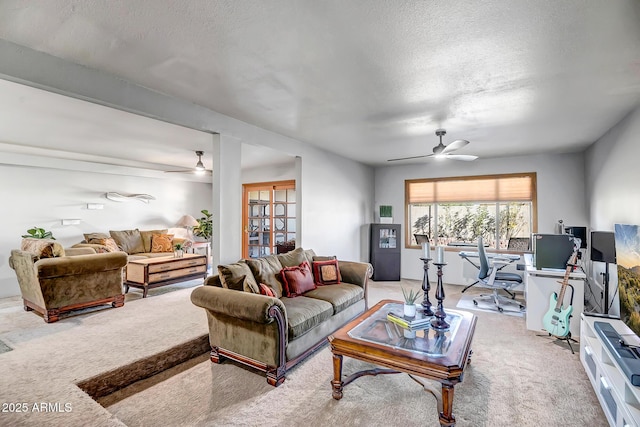 living room with a textured ceiling, ceiling fan, and carpet