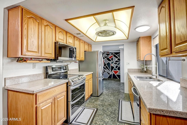 kitchen with light stone counters, appliances with stainless steel finishes, and sink