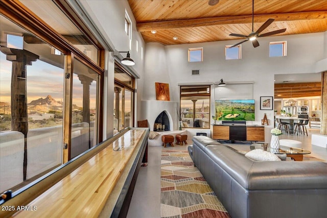 living room featuring beamed ceiling, wooden ceiling, a towering ceiling, and a healthy amount of sunlight