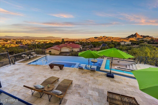 view of swimming pool with a patio area, fence, a mountain view, and a fenced in pool