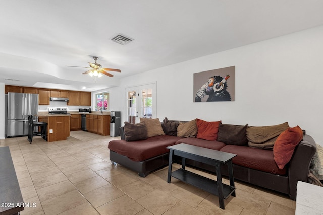 living area featuring ceiling fan, light tile patterned floors, and french doors