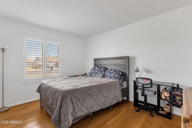 bedroom featuring wood finished floors and baseboards