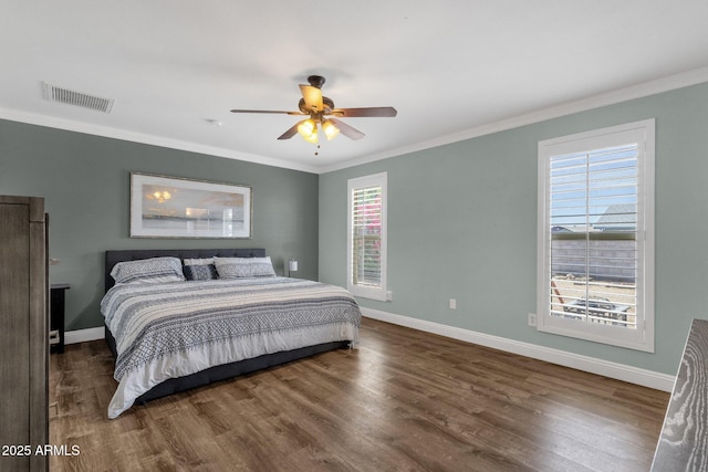 bedroom featuring wood finished floors, crown molding, baseboards, and a ceiling fan