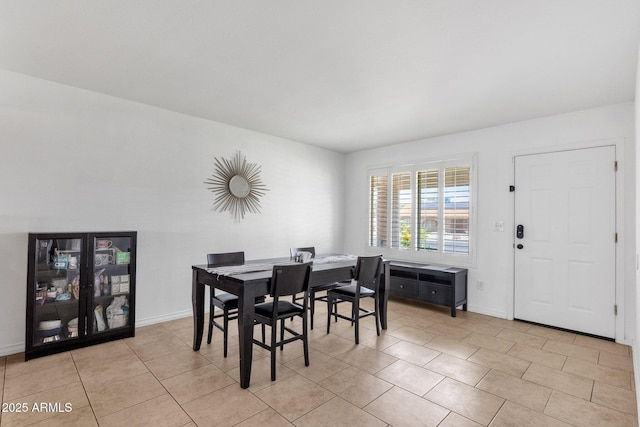 dining area featuring light tile patterned floors and baseboards