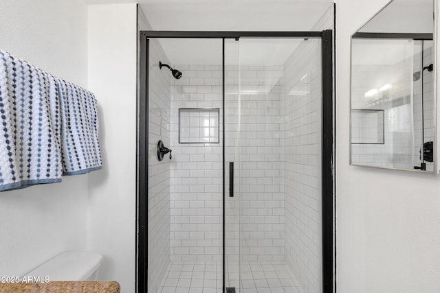 bathroom featuring toilet and a stall shower