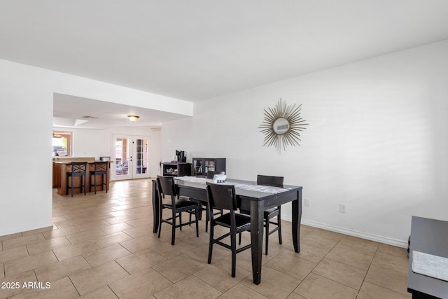 dining space with french doors, light tile patterned floors, and baseboards