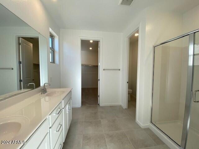 bathroom with vanity, tile patterned flooring, toilet, and walk in shower