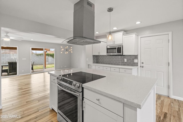 kitchen featuring island exhaust hood, appliances with stainless steel finishes, white cabinets, and pendant lighting