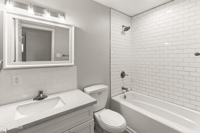 full bathroom featuring vanity, toilet, tiled shower / bath, and tasteful backsplash