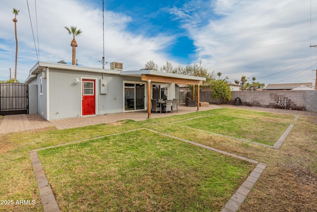 rear view of house with a lawn and a patio area