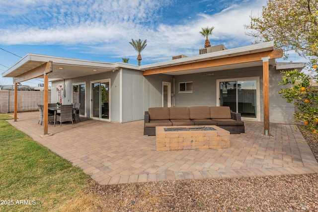 back of house featuring a patio and an outdoor living space with a fire pit