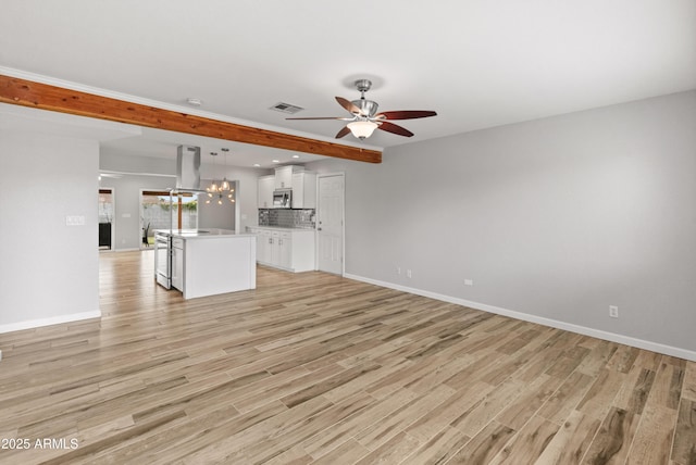 unfurnished living room with light hardwood / wood-style flooring, beamed ceiling, and ceiling fan with notable chandelier