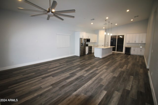 unfurnished living room with dark wood-type flooring, ceiling fan, and vaulted ceiling