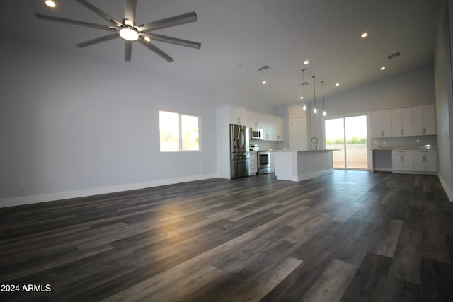 unfurnished living room featuring high vaulted ceiling, a wealth of natural light, dark wood-type flooring, and ceiling fan