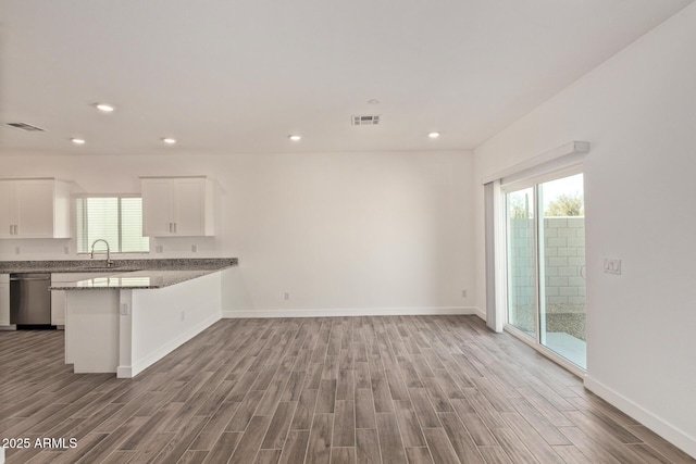 1552 N Pueblo Dr, Apache Junction, AZ 85120 - kitchen featuring stainless steel dishwasher, wood finished floors, healthy amount of natural light, white cabinetry, and recessed lighting