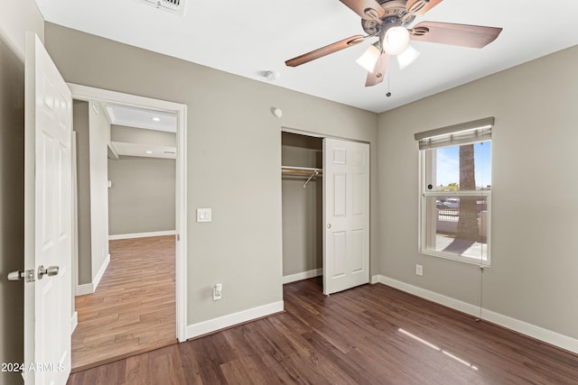 unfurnished bedroom featuring dark hardwood / wood-style floors, ceiling fan, and a closet