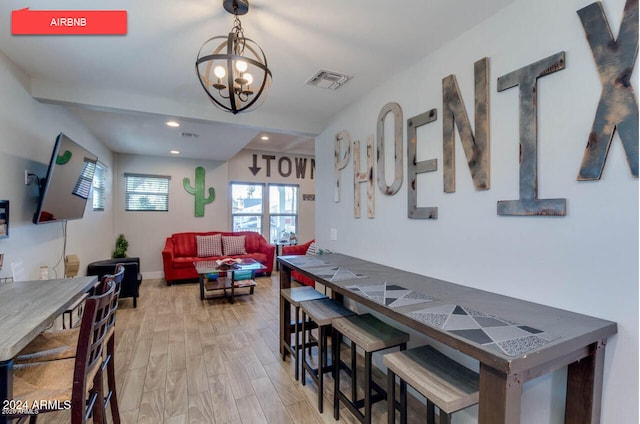 dining room featuring light hardwood / wood-style flooring and a notable chandelier