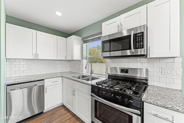 kitchen with wood-type flooring, sink, white cabinetry, and stainless steel appliances