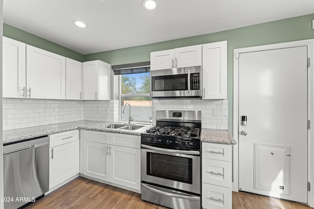 kitchen featuring sink, white cabinets, stainless steel appliances, and light hardwood / wood-style floors