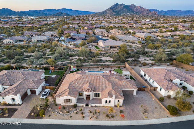 aerial view at dusk featuring a mountain view