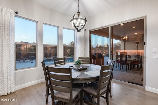 dining space featuring light wood-type flooring and a notable chandelier