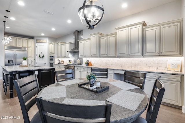 dining space featuring a chandelier, light wood-type flooring, and sink