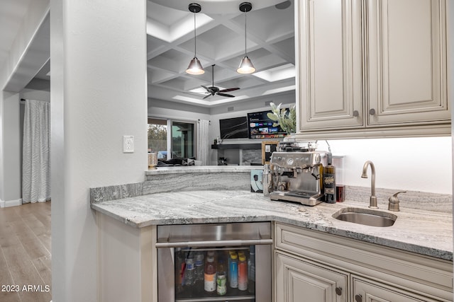 kitchen with coffered ceiling, sink, wine cooler, beamed ceiling, and light hardwood / wood-style floors