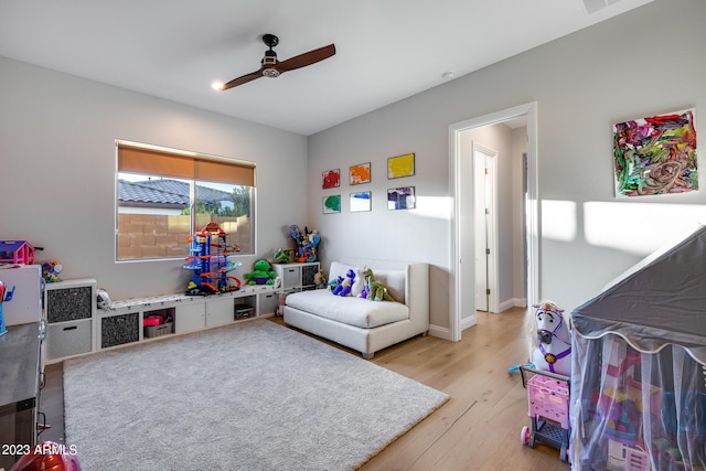 game room with ceiling fan and light wood-type flooring