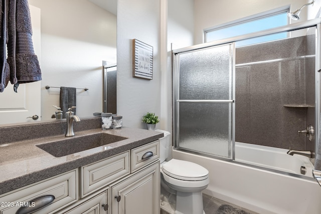 full bathroom featuring vanity, toilet, and combined bath / shower with glass door