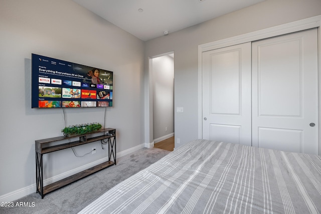 bedroom featuring light colored carpet and a closet