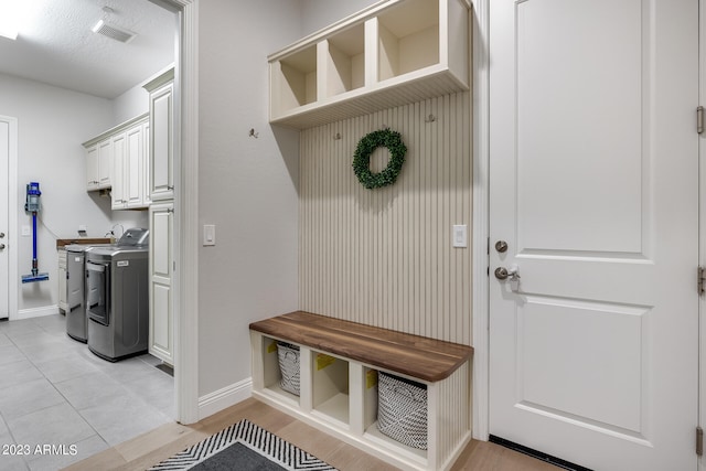 mudroom featuring light tile patterned floors, a textured ceiling, and washer / clothes dryer