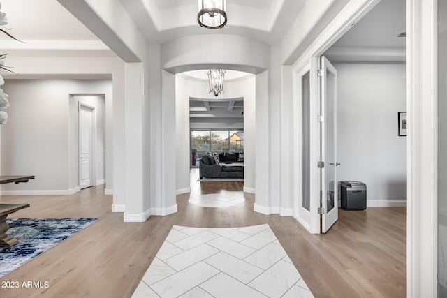 foyer entrance featuring light hardwood / wood-style flooring and an inviting chandelier