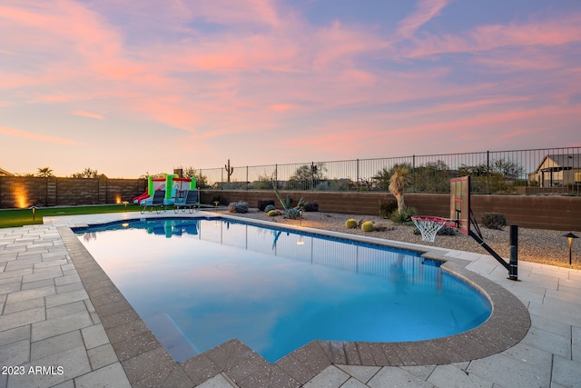 pool at dusk featuring a patio area