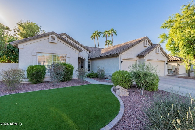 mediterranean / spanish-style house with a front lawn, a tile roof, stucco siding, driveway, and an attached garage