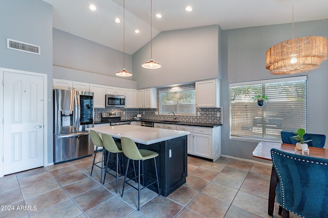 kitchen with visible vents, a sink, backsplash, white cabinetry, and stainless steel appliances