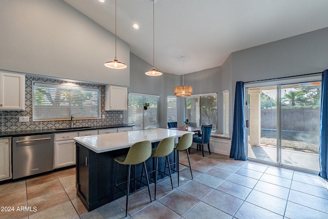 kitchen featuring dishwasher, light tile patterned floors, white cabinetry, and a sink