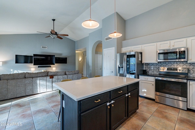 kitchen with decorative light fixtures, white cabinetry, a kitchen island, decorative backsplash, and stainless steel appliances