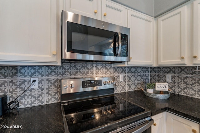 kitchen with stainless steel appliances, backsplash, and white cabinetry