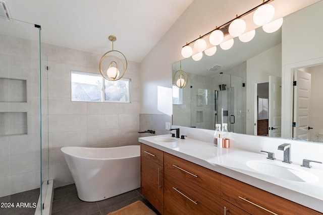 full bath featuring a stall shower, a sink, tile patterned flooring, double vanity, and lofted ceiling